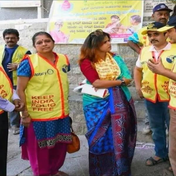 People participating in a Rotary Club community event promoting cleanliness and awareness on the street.